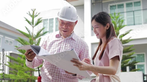 House construction contractor holds blueprints and stands talking to homeowner customer. Discuss construction details. Home inspection expert. Real estate business