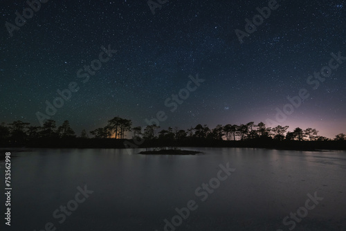 Landscape astrophoto on swamp lake in winter. Nature of Estonia.