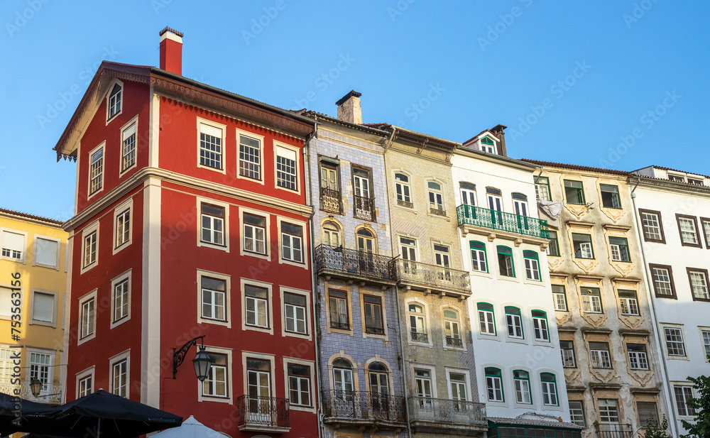 Facades of old buildings in the city center of Coimbra in Portugal, with a beautiful pattern of windows.