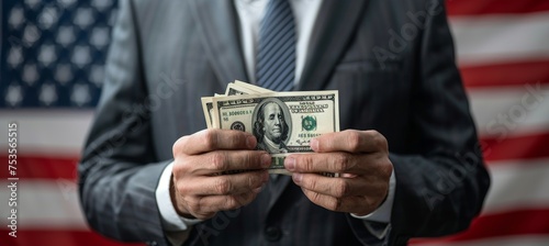 Businessman hands holding dollar bills on blurred american flag background, with copy space