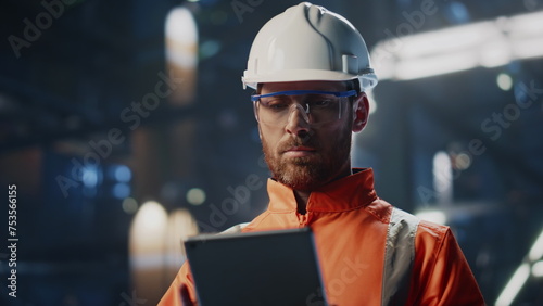 Skilled technician inspecting production industrial facility with tablet closeup