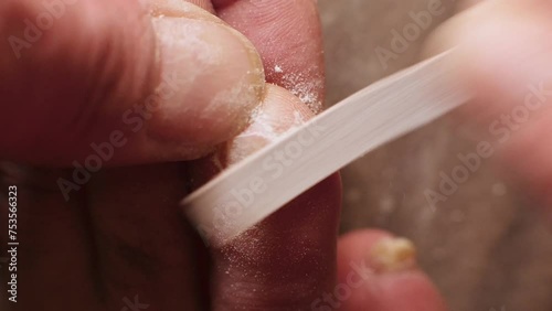 emery boards filing down a toe nail with fungal infections. close up photo