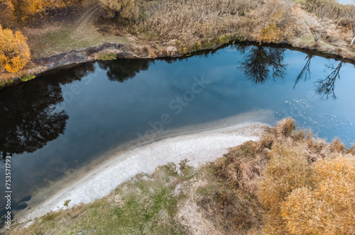 Aerial look down on river sand shore in autumn