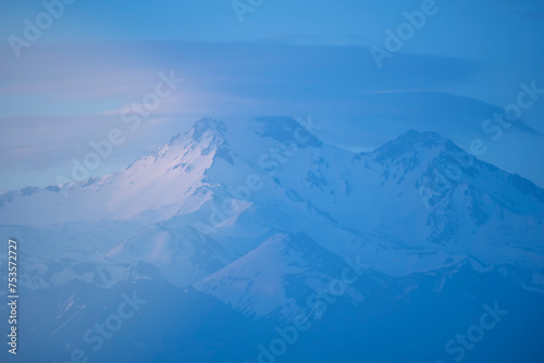 colorful snowy mountains distant shot at sunset time © Aytug Bayer