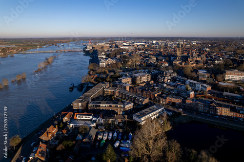 IJssel valley with tower town Zutphen, The Netherlands along the river meandering towards the horizon. Aerial Dutch waterway landscape