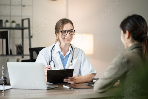 Female doctor sitting at work looking at the history of patients in the clinic or in the hospital