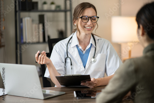 Female doctor sitting at work looking at the history of patients in the clinic or in the hospital