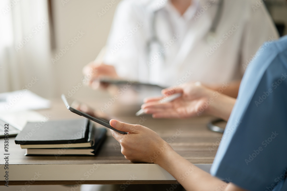 Female doctor sitting at work looking at the history of patients in the clinic or in the hospital
