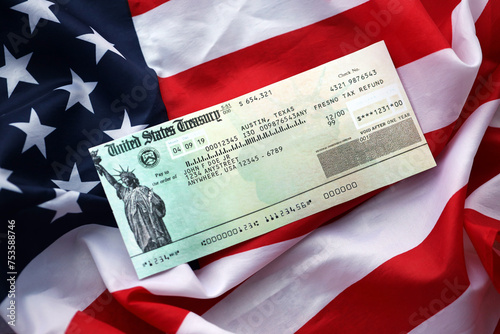 United States Treasury Refund check on waving American Flag close up. photo