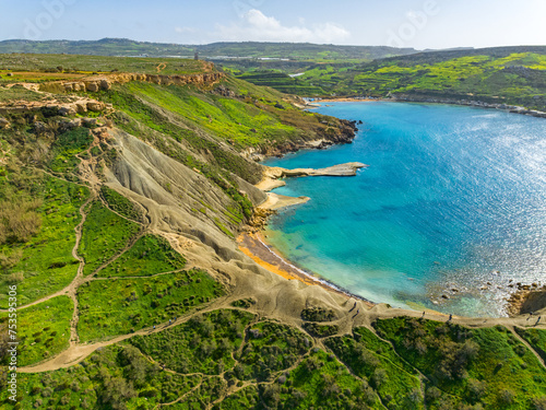 Fototapeta Naklejka Na Ścianę i Meble -  Ghain Tuffieha bay and beach. Spring, green countryside. Malta island, aerial view