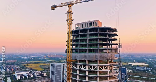 Aerial view of construction site at sunset. High rise buildings in construction site. Unfinished building scene. Drone surround shooting. photo