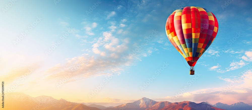 Colorful Hot Air Balloon Soaring Above Majestic Mountain Range Landscape