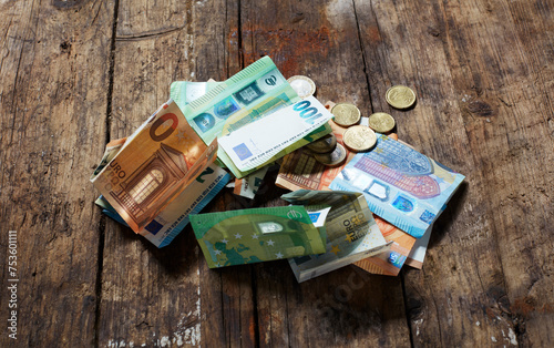 Geld Scheine und Münzen, verloren ungeordnet auf altem Holz photo
