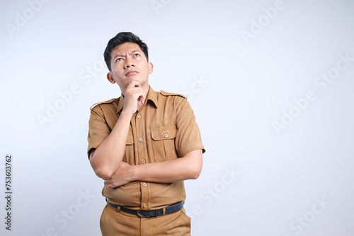 Male Asian civil servants or state civil servants in brown uniform thinking while looking up photo