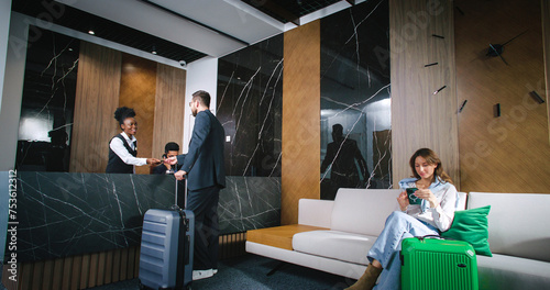Foto Gorgeous businessman checking in hotel room having conversation with professional and kind receptionist helping guests