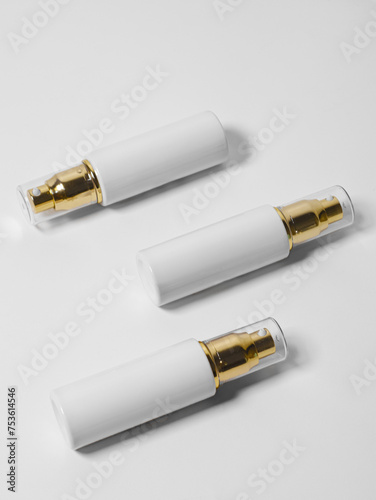Cosmetic spray and serum bottle on white background