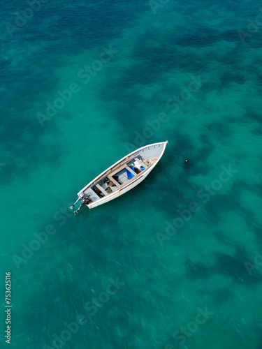 Aerial top view of a fishing boat in a turquoise sea © Ashley
