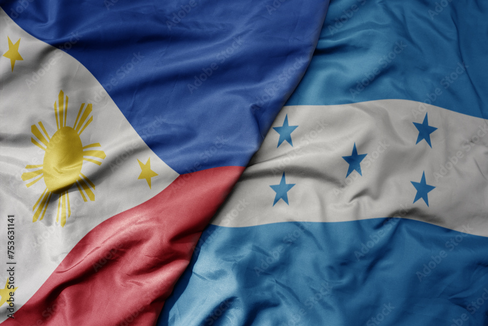 big waving national colorful flag of honduras and national flag of philippines.