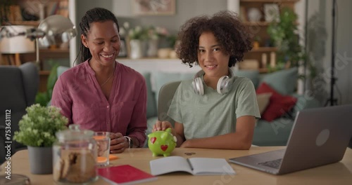 Mother and her teenage son saving money in piggy bank