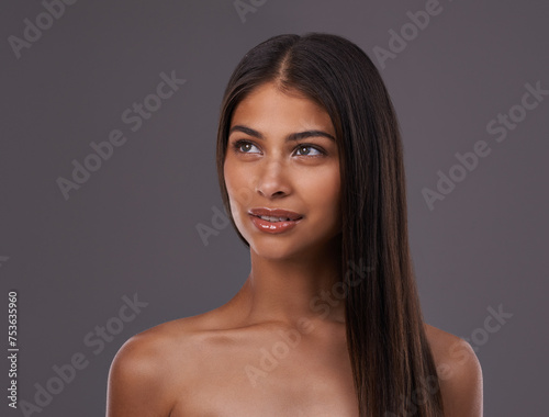 Thinking, hair and face of woman in on gray background for healthy texture, wellness and beauty. Haircare, hairdresser and person with long hairstyle for salon products, cosmetics and shine in studio