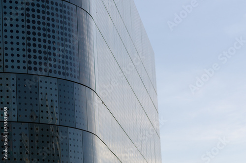 Modern building facade  with innovative designed solar protection system on a south-facing glass facade. semicircular building  with wavy lines of molded glass. modular curtain walls