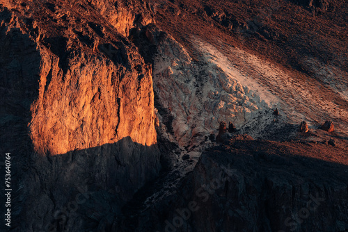 Dusk light paints a vivid contrast on a mountain face in Patagonia, Argentina, highlighting the intricate geological textures and formations photo