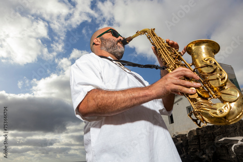 Saxophonist Performs Outdoors Against Cloudy Sky photo