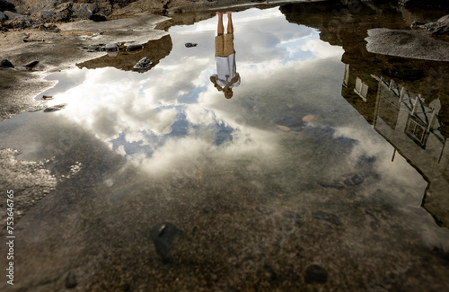 Upside-down reflection of man in a puddle photo