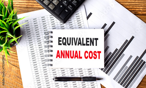 EQUIVALENT ANNUAL COST text on a notebook with chart and calculator photo