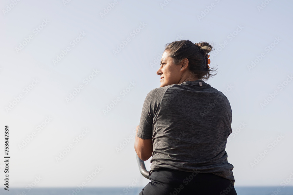 Woman at outdoor beach gym enjoying the sea view Woman at outdoor beach gym enjoying the sea view