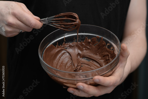 Rozpuszczona czekolada, polewa czekoladowa w miseczce i trzepaczka do mieszania