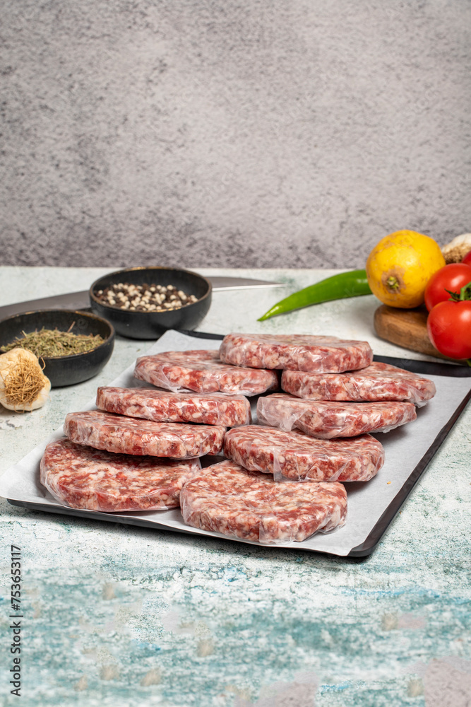 Raw hamburger Patty. Butcher products. Raw hamburger patties with gelatin on a stone background Raw hamburger Patty. Butcher products. Raw hamburger patties with gelatin on a stone background