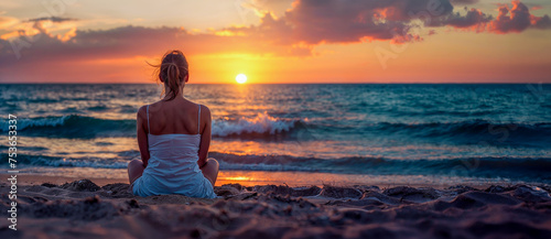 jeune femme assise de dos sur la plage en train de regarder le coucher de soleil