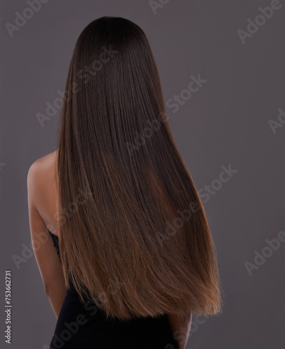 Hair care, wind and body of woman with beauty, shine or back isolated on a gray studio background. Hairstyle, cosmetics and rear view of model in salon for treatment, growth or hairdresser for glow