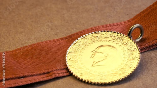 Turkish Republic gold coin with ribbon. A spinning Republic of Turkey gold coin. Atatürk silhouette. photo