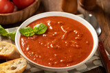 Bowl of tomato soup garnished with basil leaves