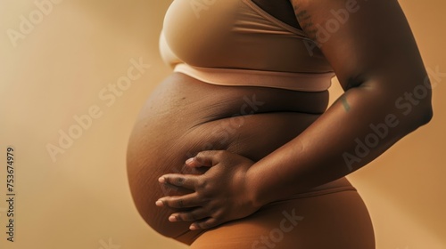 The image captures the beauty and intimacy of pregnancy with a woman gently holding her belly in maternity wear