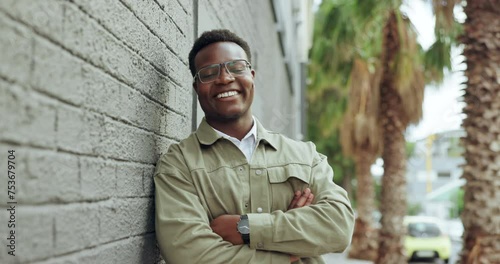 Black man, smile and wall in city with happiness for confidence, positive attitude and good mood. Pride, male person and face with glasses for vision, portrait and fashion outdoors in Atlanta photo