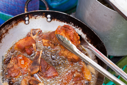 Photograph of pork frying in hot oil to prepare Peruvian chicharron. Peruvian food concept.