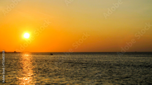  Blurred picture of sunset view from the beach. Beautiful scenery background. © AlvianTito