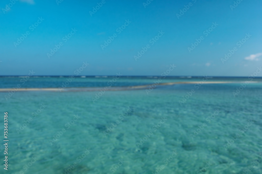 Blurred picture of little white sand island beach and blue sky. Beautiful scenery background.