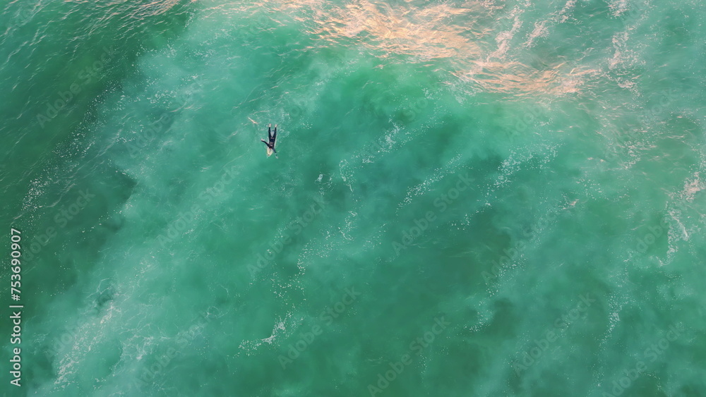 Fototapeta premium Aerial surfer swimming ocean summer weekend. Top shot surfboarder lying wave