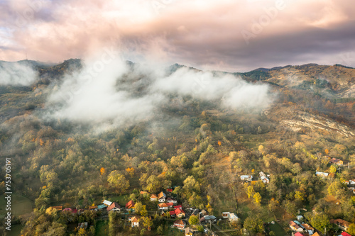 Morning view with mountain village and fog an clouds in Romania