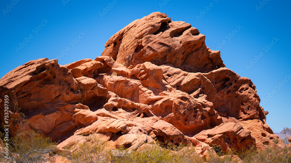 Desert rocks under bright sun against clear blue sky