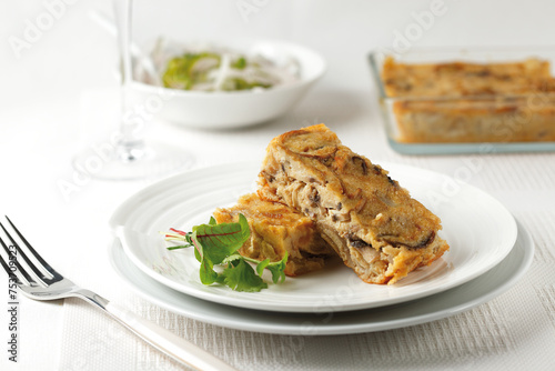 Slices of mushroom pie served on a white plate. Space for text..