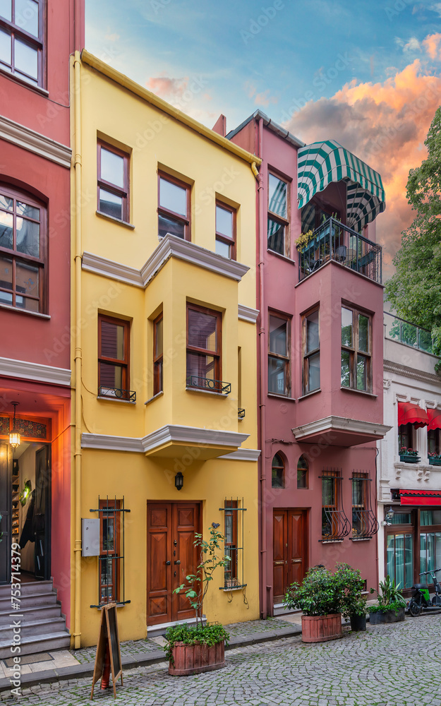 Facade of colorful residential buildings painted in red and yellow, at cobblestone alley suited in Kuzguncuk neighborhood, Uskudar district, Istanbul, Turkey