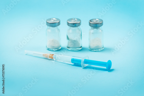 Syringe and needle with glass medical ampoule vials for injection. Medicine is dry white drug penicillin powder or liquid with of aqueous solution in ampulla