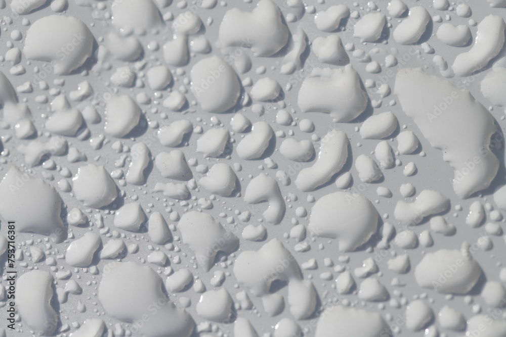 Obraz premium Close-up, background and close-up of a white lacquered surface on which many water pearls shimmer.