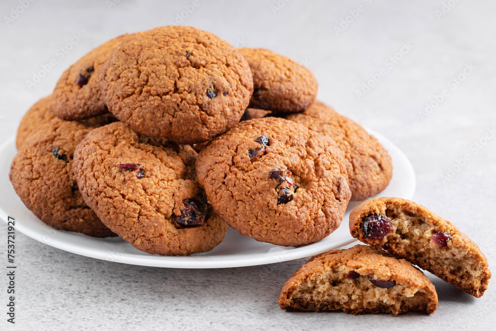 On a light background on a plate there are oatmeal cookies with dried cranberries. On a light background on a plate there are oatmeal cookies with dried cranberries.