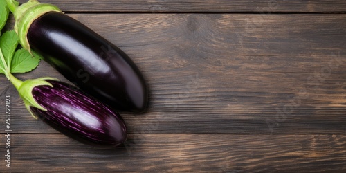 Fresh, glossy eggplant on wood table, flat lay with room for text. photo